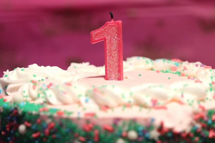 A cake with a number 1 candle on it